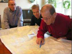 Bengt Larsson och Thorvald Nielssen iakttar Jim Danielsson som granskar en karta 2007